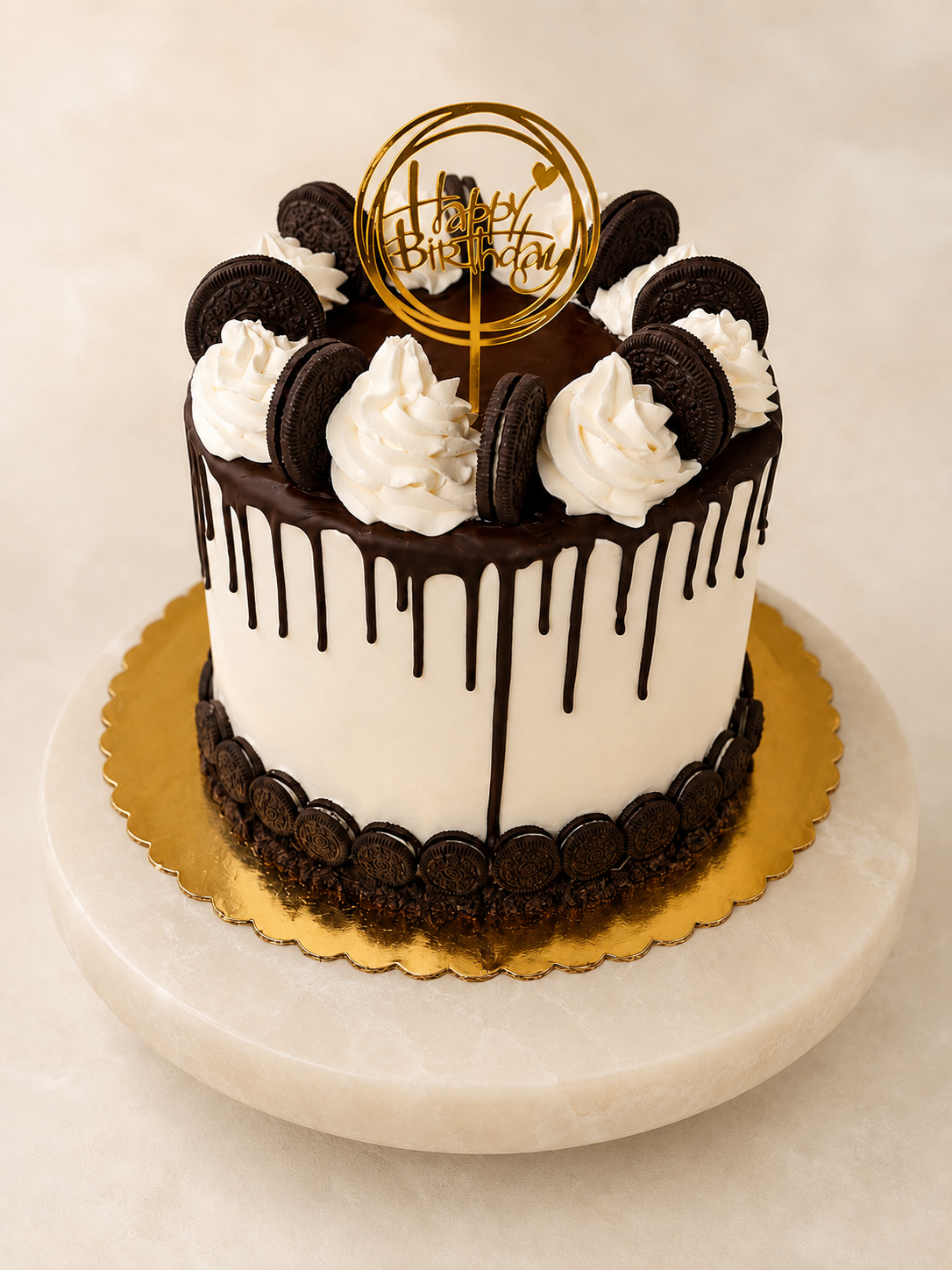 Oreo chocolate drip cake with cream swirls and gold topper